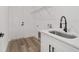 Well-lit laundry room features white cabinetry, sleek black hardware, and modern sink fixture at 8850 Sw 125Th Ter, Dunnellon, FL 34432