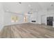 Open living room with wood-look flooring, providing access to both the modern kitchen and a cozy fireplace at 8850 Sw 125Th Ter, Dunnellon, FL 34432