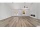 Modern living space featuring wood-look floors, offering a view of the front entry and sleek electric fireplace at 8850 Sw 125Th Ter, Dunnellon, FL 34432