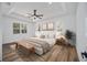 Serene main bedroom features a tray ceiling, large windows, and wood-style flooring at 8850 Sw 125Th Ter, Dunnellon, FL 34432