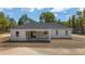 Rear exterior of the house featuring a covered porch and a large yard, perfect for outdoor activities at 8850 Sw 125Th Ter, Dunnellon, FL 34432