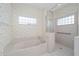 Well-lit bathroom featuring a bathtub, separate walk-in shower, and a tile floor at 8869 Sw 194Th Ct, Dunnellon, FL 34432