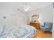 Bright bedroom with a floral bedspread, ceiling fan, and wood floors at 8869 Sw 194Th Ct, Dunnellon, FL 34432