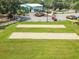 Aerial view of the community bocce ball courts, clubhouse and lush green surroundings at 8869 Sw 194Th Ct, Dunnellon, FL 34432