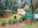 Community park featuring a gazebo, guard house, and beach access rules, all within a beautifully landscaped setting at 8869 Sw 194Th Ct, Dunnellon, FL 34432