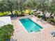 Aerial view of the community pool, lounge seating, lush landscaping, and mature trees at 8869 Sw 194Th Ct, Dunnellon, FL 34432