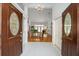Inviting foyer with soaring ceilings, white tile flooring, and wood doors leading to the living area at 8869 Sw 194Th Ct, Dunnellon, FL 34432