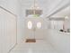 Bright and airy foyer featuring white tile floors, a chandelier, and decorative glass doors at 8869 Sw 194Th Ct, Dunnellon, FL 34432