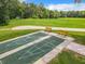 Aerial view of community shuffleboard courts with benches and lush landscaping at 8869 Sw 194Th Ct, Dunnellon, FL 34432