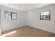 Sun-lit bedroom featuring wood-look flooring and large windows offering views of the surroundings at 10690 Se 44Th Ter, Belleview, FL 34420