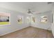 Bonus room with hardwood floors, ceiling fan, and bright natural light from multiple windows at 10690 Se 44Th Ter, Belleview, FL 34420