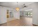 Bright living room with hardwood floors, chandelier, ceiling fan, and large windows at 10690 Se 44Th Ter, Belleview, FL 34420