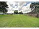 Large, grassy backyard featuring a wooden fence and mature trees at 10750 Nw 7Th St, Ocala, FL 34482