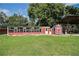 View of chicken coop in the backyard featuring a red storage shed at 10750 Nw 7Th St, Ocala, FL 34482