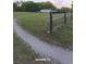 Fenced lot showing the property and access road to a quaint home in the background at 10750 Nw 7Th St, Ocala, FL 34482