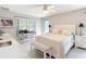 Bright bedroom boasts a serene atmosphere with a comfortable bed, stylish decor, and sunroom access at 11010 Se 174Th Loop, Summerfield, FL 34491
