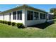 Sunroom on the exterior of the house, surrounded by green lawn and landscaping at 11010 Se 174Th Loop, Summerfield, FL 34491