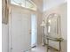 Bright foyer with white tile flooring, decorative mirror, and glass-topped table, creating a welcoming entrance at 11010 Se 174Th Loop, Summerfield, FL 34491