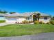 Charming single-story home featuring a well-manicured lawn, vibrant landscaping, and a welcoming front entrance at 11010 Se 174Th Loop, Summerfield, FL 34491