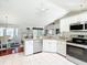 Bright kitchen with white cabinets, stainless steel appliances, and a view into the adjacent dining area at 11010 Se 174Th Loop, Summerfield, FL 34491