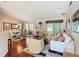 Spacious living room with hardwood floors, neutral decor, comfortable seating, and large windows at 11010 Se 174Th Loop, Summerfield, FL 34491
