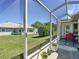 This screened-in patio provides a relaxing view of the home's exterior, landscaping, and well-maintained lawn at 11010 Se 174Th Loop, Summerfield, FL 34491