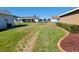 Wide backyard with grass, chain link fence, partial grass coverage and view of neighboring houses at 11395 Sw 139Th St, Dunnellon, FL 34432