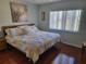 Comfortable bedroom featuring a queen-sized bed, ample natural light, and wood flooring at 11395 Sw 139Th St, Dunnellon, FL 34432