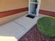 Close-up of front door with a storm door, concrete entryway, and decorative rock mulch at 11395 Sw 139Th St, Dunnellon, FL 34432