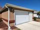 Attached garage with ample parking space featuring carriage lights and updated door at 11395 Sw 139Th St, Dunnellon, FL 34432