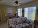 Cozy living room featuring floral sofa, dining table, and natural light from the windows at 11395 Sw 139Th St, Dunnellon, FL 34432