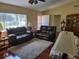 Cozy living room with plush seating, a large window letting in natural light, and a decorative cabinet at 11395 Sw 139Th St, Dunnellon, FL 34432