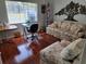 Cozy living room with floral seating, a workspace, and natural light at 11395 Sw 139Th St, Dunnellon, FL 34432