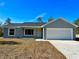 Charming single-story home with gray exterior, well-maintained lawn, and two-car garage in a suburban neighborhood at 12 Fisher Loop Ct, Ocklawaha, FL 32179