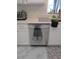 Stainless steel dishwasher in a kitchen with white cabinets, light countertops and tile floors at 13780 Sw 111Th Ave, Dunnellon, FL 34432
