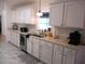 Bright and airy kitchen featuring white cabinets, stainless steel appliances, and generous counter space at 13780 Sw 111Th Ave, Dunnellon, FL 34432