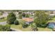 Backyard view of a home, showing a screened in porch, mature trees, manicured landscaping, and a swimming pool at 13805 Se 87Th Ter, Summerfield, FL 34491