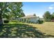 Expansive backyard with lush green grass and partial view of home, showcasing privacy and outdoor space at 13805 Se 87Th Ter, Summerfield, FL 34491