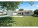 Charming single-story home featuring a lush lawn, decorative fountain, and attached two-car garage at 13805 Se 87Th Ter, Summerfield, FL 34491