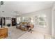 Comfortable living room featuring neutral tones, tile flooring, and an abundance of natural light from two windows at 13805 Se 87Th Ter, Summerfield, FL 34491