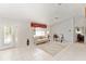 Bright living room with neutral tile flooring, and large window with a valance, adding character to the space at 13805 Se 87Th Ter, Summerfield, FL 34491