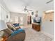 Spacious living room with open floor plan, ceiling fan, comfortable seating, and large windows at 13805 Se 87Th Ter, Summerfield, FL 34491
