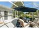 Relaxing screened-in patio featuring a dining table, chairs, and an umbrella for shaded outdoor enjoyment at 13805 Se 87Th Ter, Summerfield, FL 34491