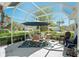 Screened-in patio with a seating area covered by an umbrella, an inviting space for outdoor gatherings at 13805 Se 87Th Ter, Summerfield, FL 34491