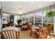 A bright sunroom with glass windows, wicker furniture, neutral décor, and lots of light at 1689 Van Buren Way, The Villages, FL 32162