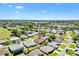 Aerial view of a single story home in a well manicured neighborhood with a pond nearby at 17472 Se 112Th Ct, Summerfield, FL 34491