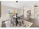 Inviting dining area with a modern light fixture, stylish chairs, and a view of the lush front yard at 17472 Se 112Th Ct, Summerfield, FL 34491