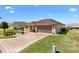 Landscaped front yard leading to a well-maintained home with a two-car garage and driveway at 17472 Se 112Th Ct, Summerfield, FL 34491