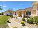 Inviting walkway adorned with flowering plants leading to the home's covered entryway at 17472 Se 112Th Ct, Summerfield, FL 34491