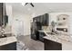 Well-lit kitchen with dark wood cabinets, stainless steel refrigerator, and granite countertops with stylish backsplash at 17472 Se 112Th Ct, Summerfield, FL 34491
